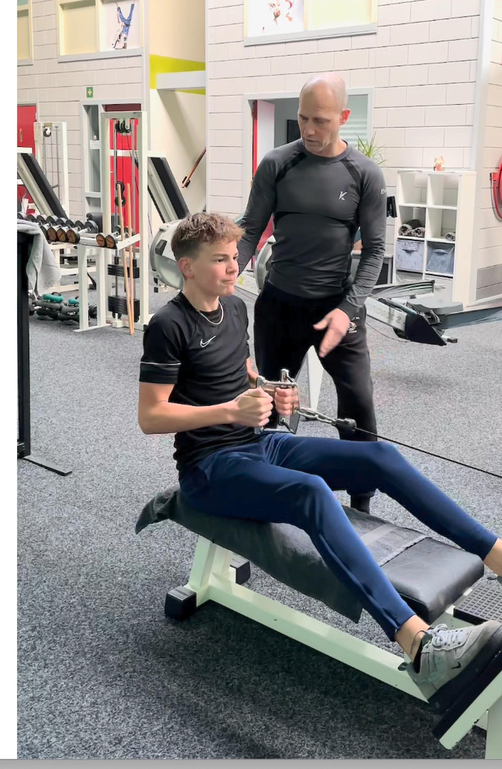 Trainer begeleidt een sporter tijdens fitness in de fitnessruimte van TRYITOUT