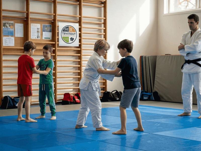 Op de blauwe judomat zijn kinderen fanatiek aan het trainen.