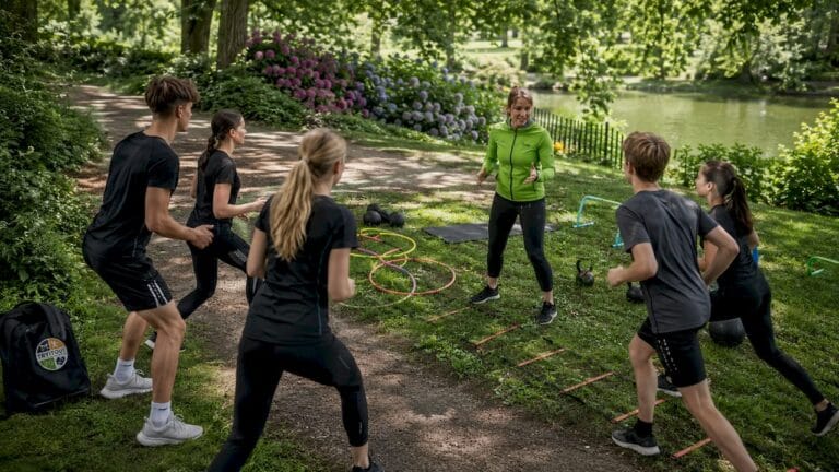 Buiten coacht de trainer een groepje jonge sporters.
