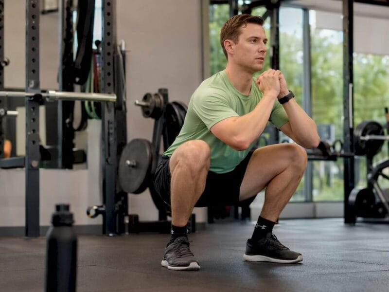 Beginnende sporter die een correcte squat uitvoert tijdens een Tabata-workout