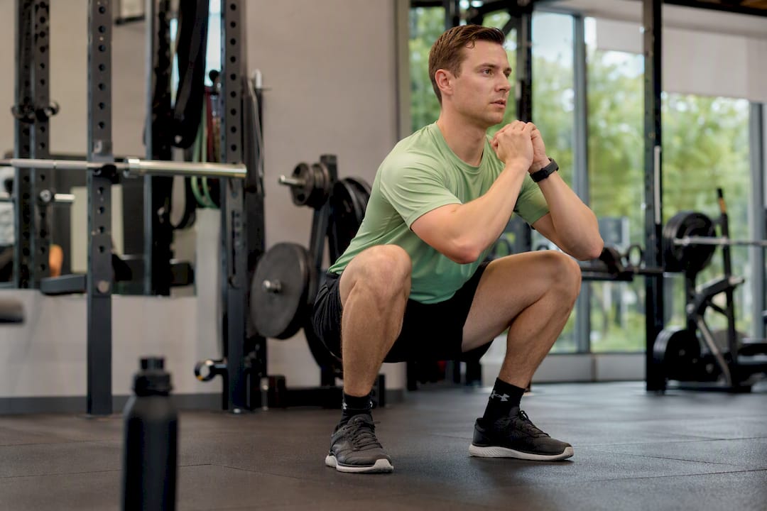 Beginnende sporter die een correcte squat uitvoert tijdens een Tabata-workout