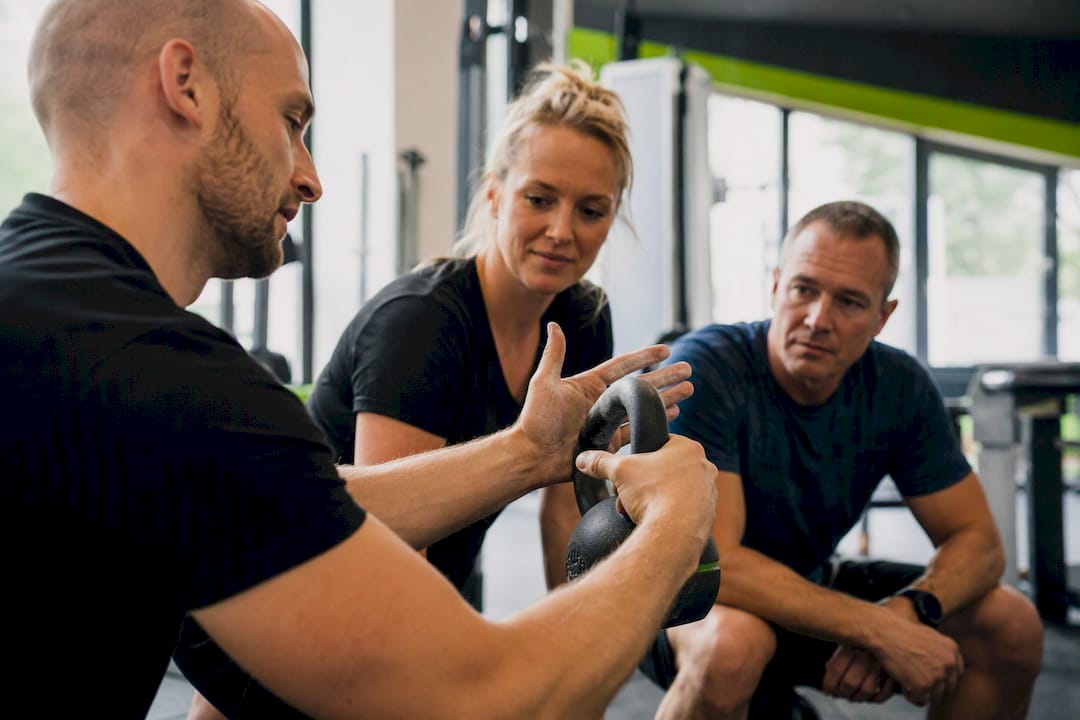 Trainer toont kettlebell-oefening aan groep