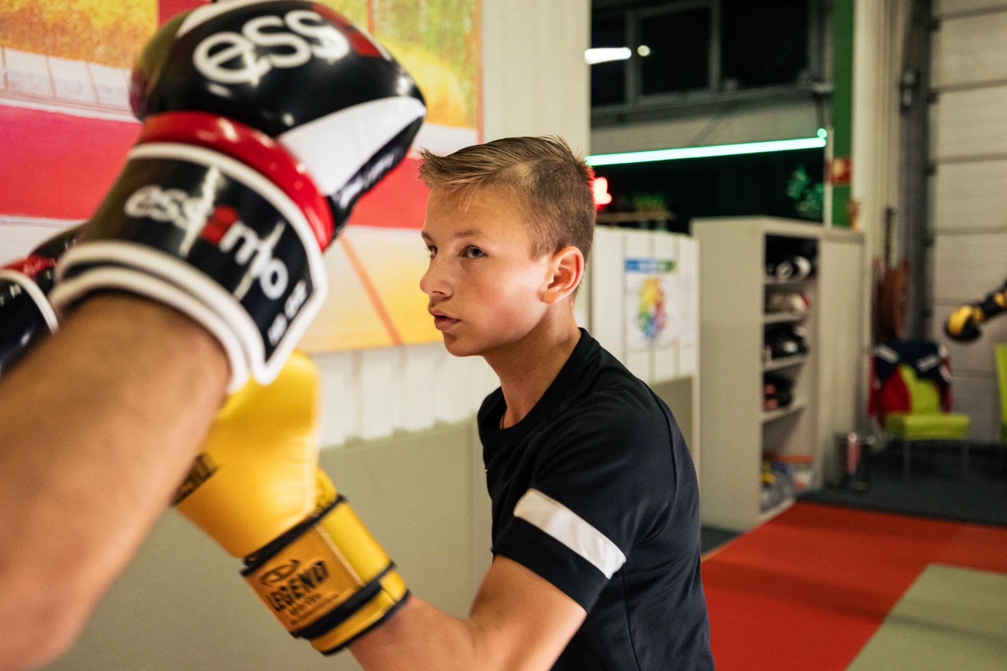 Deelnemer traint gecontroleerd op de bokshandschoenen van een trainingspartner tijdens Cardio Kickboksen bij TRYITOUT.