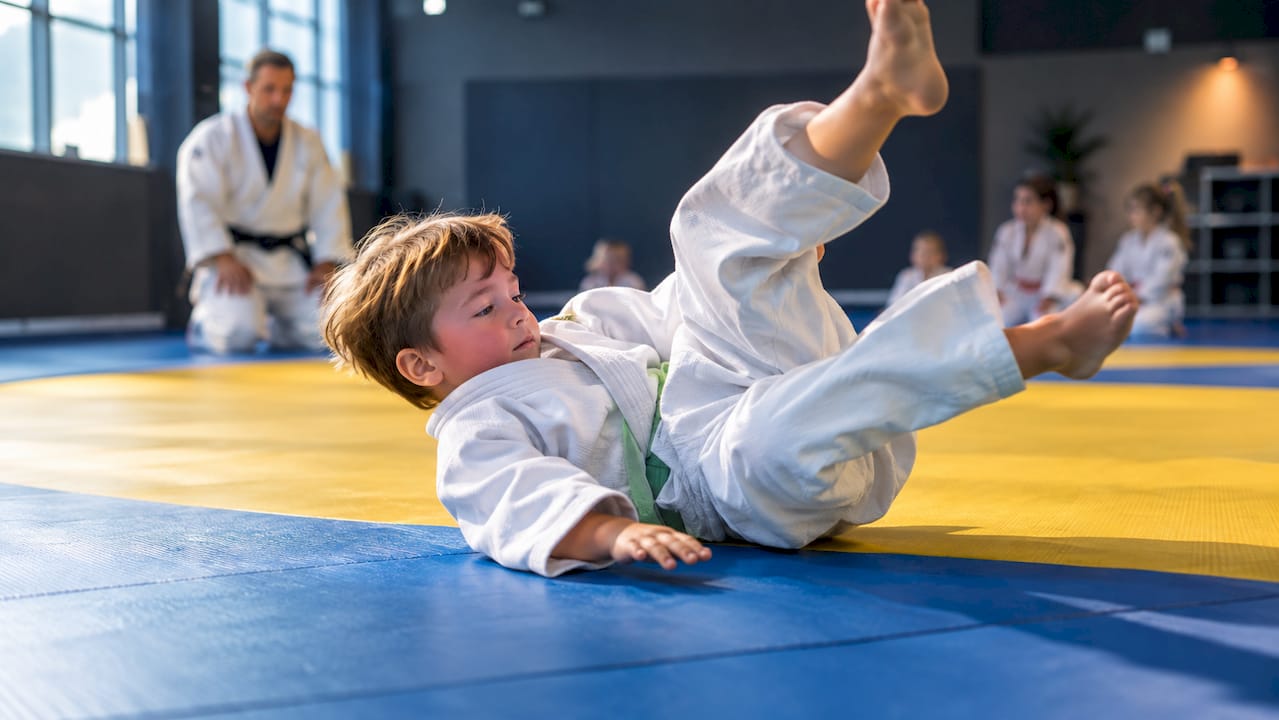 Kind maakt een veilige judorol op de mat