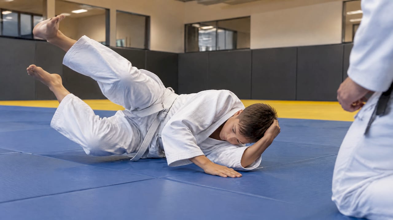 Jongen oefent veilig vallen tijdens judo